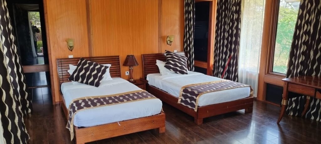 AA Lodge Maasai Mara twin-room interior with wooden floors and patterned curtains