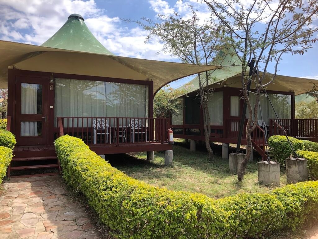 AA Lodge Maasai Mara glass-walled chalets with canvas roofs and raised verandas
