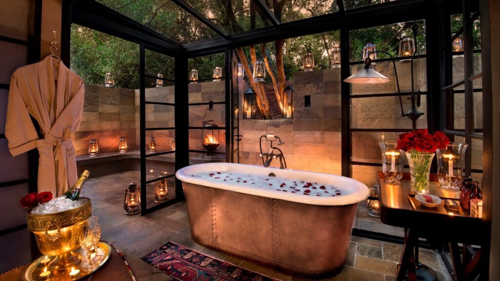 Bathtub and stone-walled outdoor shower at andBeyond Bateleur Camp