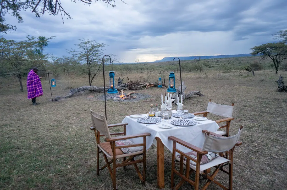 Bush dining in the Maasai Mara: breakfast, dinner and sundowners 1 Bush dining table with chairs and lanterns in open woodland