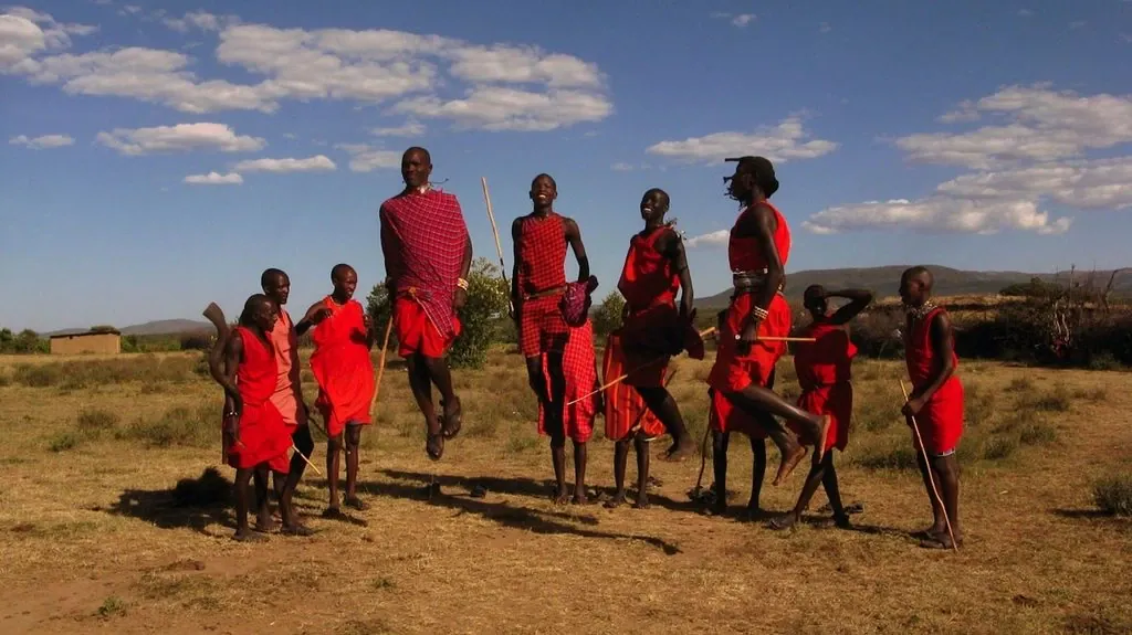 A thoughtful approach to a Maasai cultural visit 1 Maasai men in red shukas performing a jumping dance on grassland in Kenya, an illustration for cultural tour planning