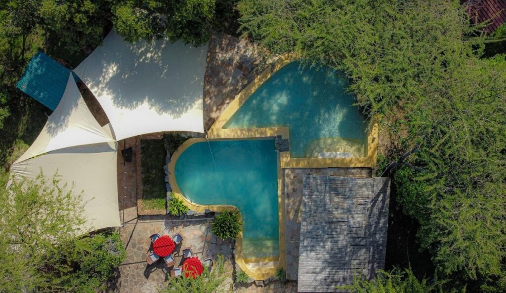 Maasai Mara lodges and camps 8 Drunken Elephant Mara swimming pool and shaded stone terrace seen from above