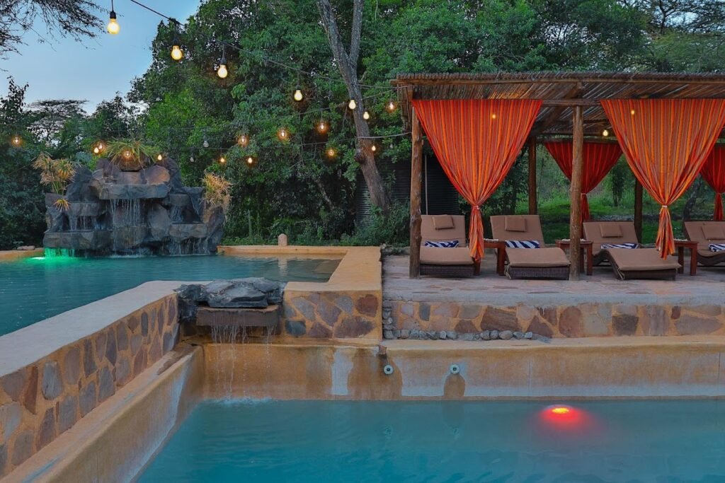 Drunken Elephant Mara pool with stone terrace and orange-curtained shaded cabanas