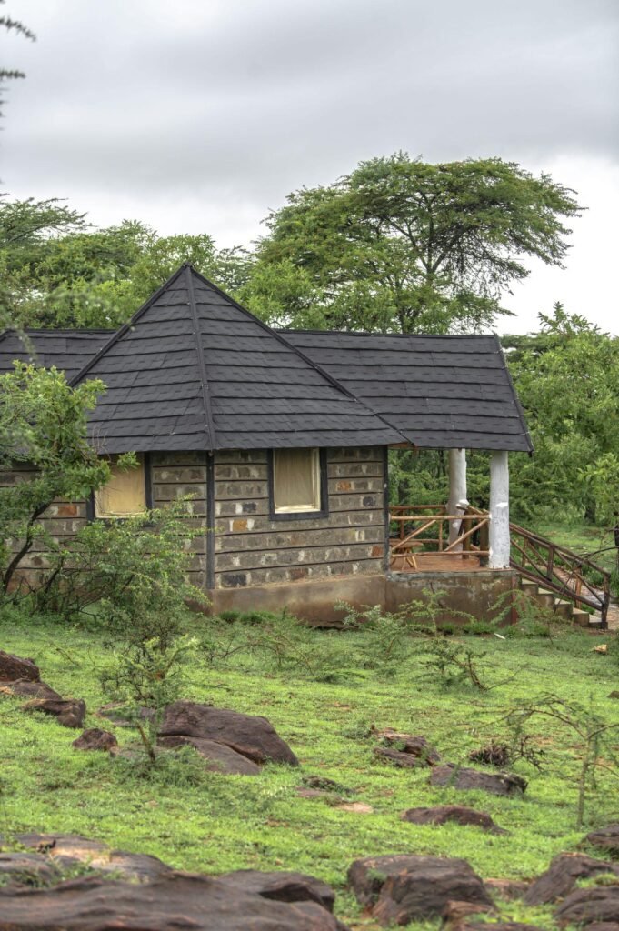 Elangata Olerai guest accommodation exterior with a raised veranda and steps among trees