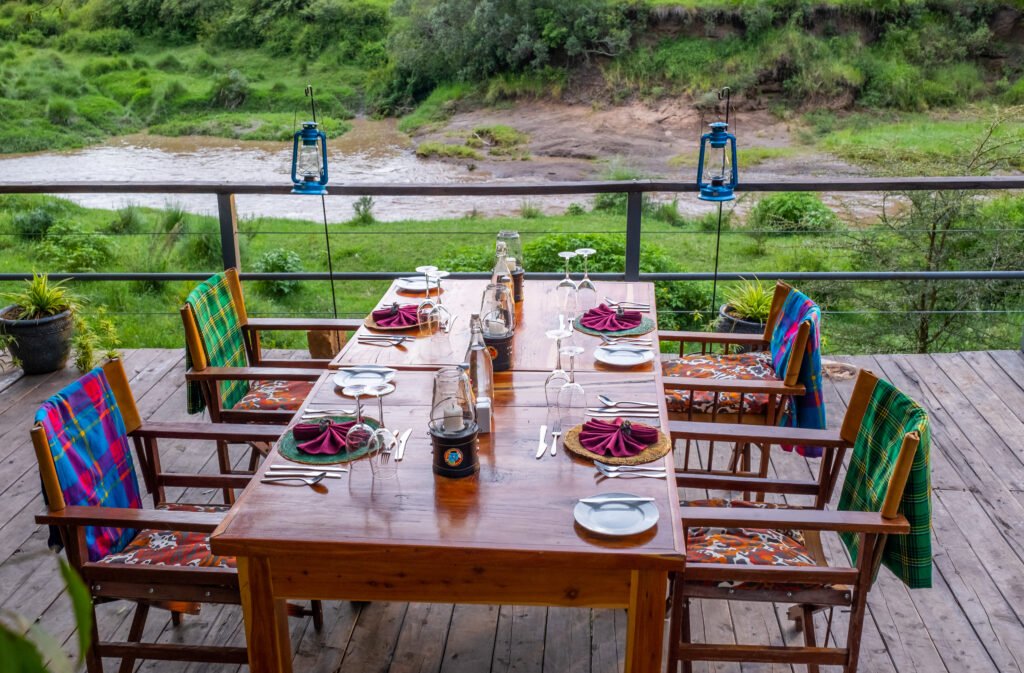 Enkakenya Mara Camp shared dining table above the Olare Orok River