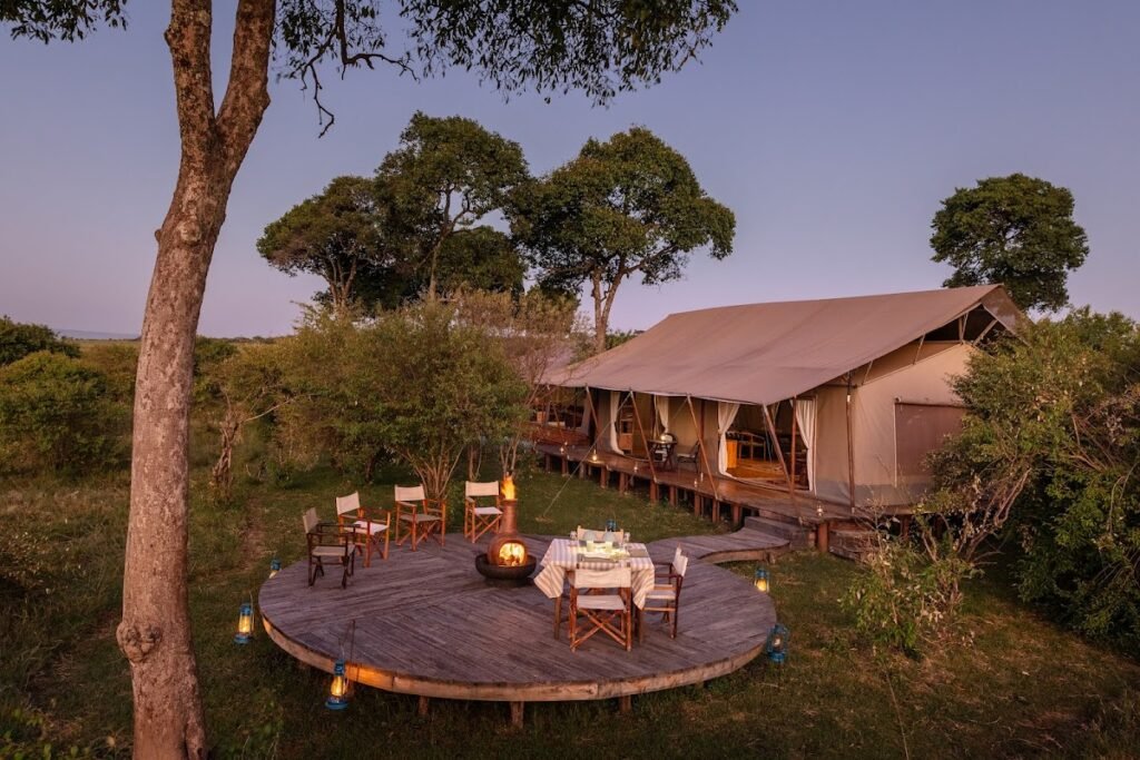 Maasai Mara lodges and camps 23 Enkusero Mara communal canvas tent and circular campfire deck at dusk