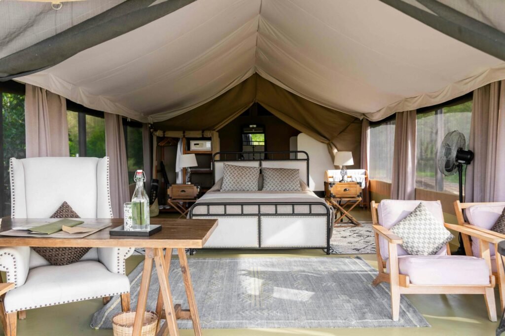 Maasai Mara lodges and camps 24 Entim Main Camp canvas tent sleeping area with bed and seating