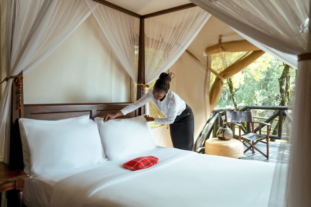 Bed being prepared inside a Fairmont Mara Safari Club canvas guest tent