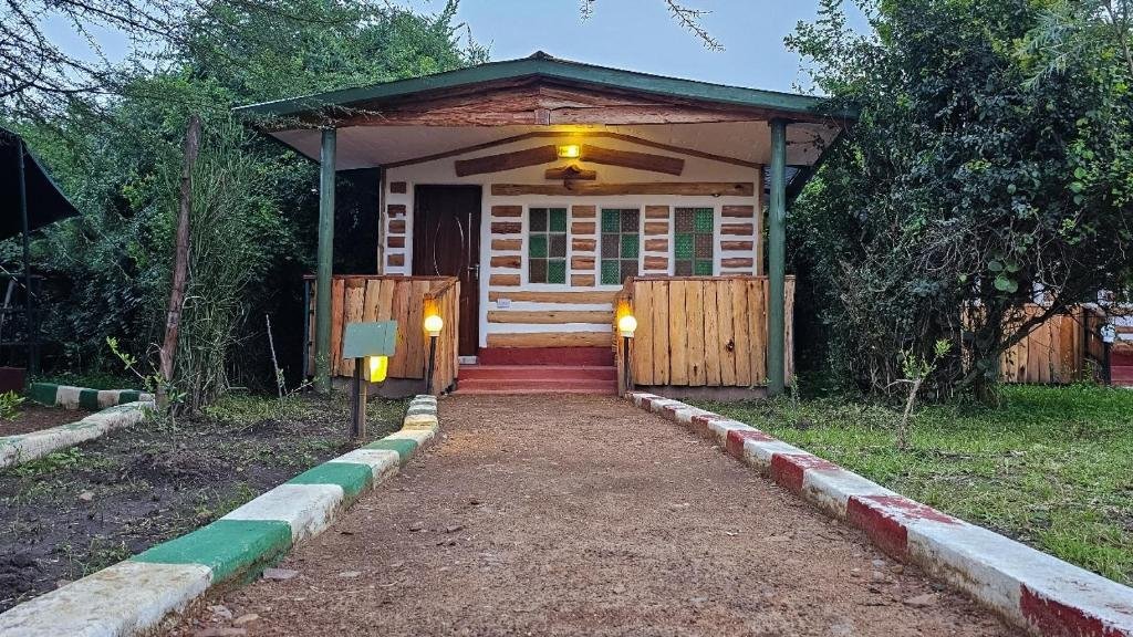 Maasai Mara lodges and camps 16 Greenwood Safari Camp private-room exterior with timber veranda in leafy grounds