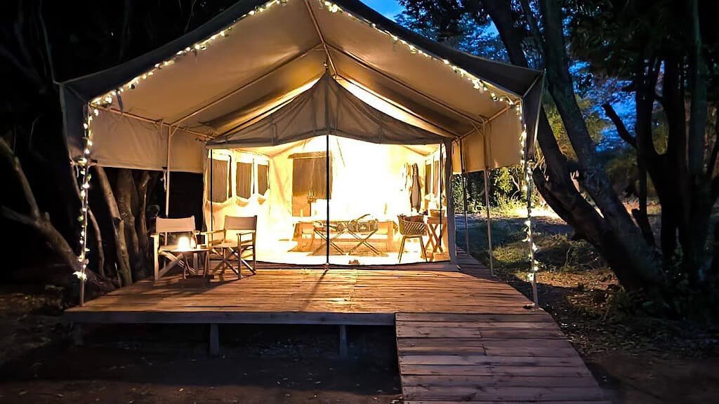 Illuminated safari tent with a wooden entrance deck