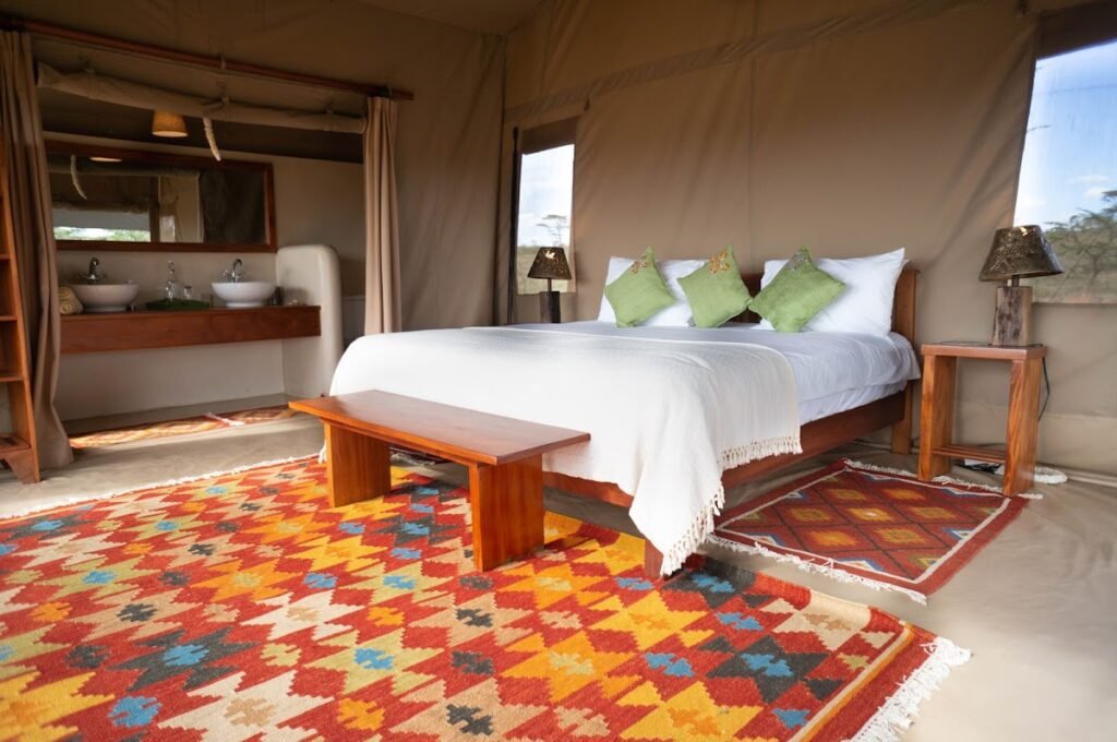 Double bed and patterned rug inside a Kandili Camp canvas guest tent