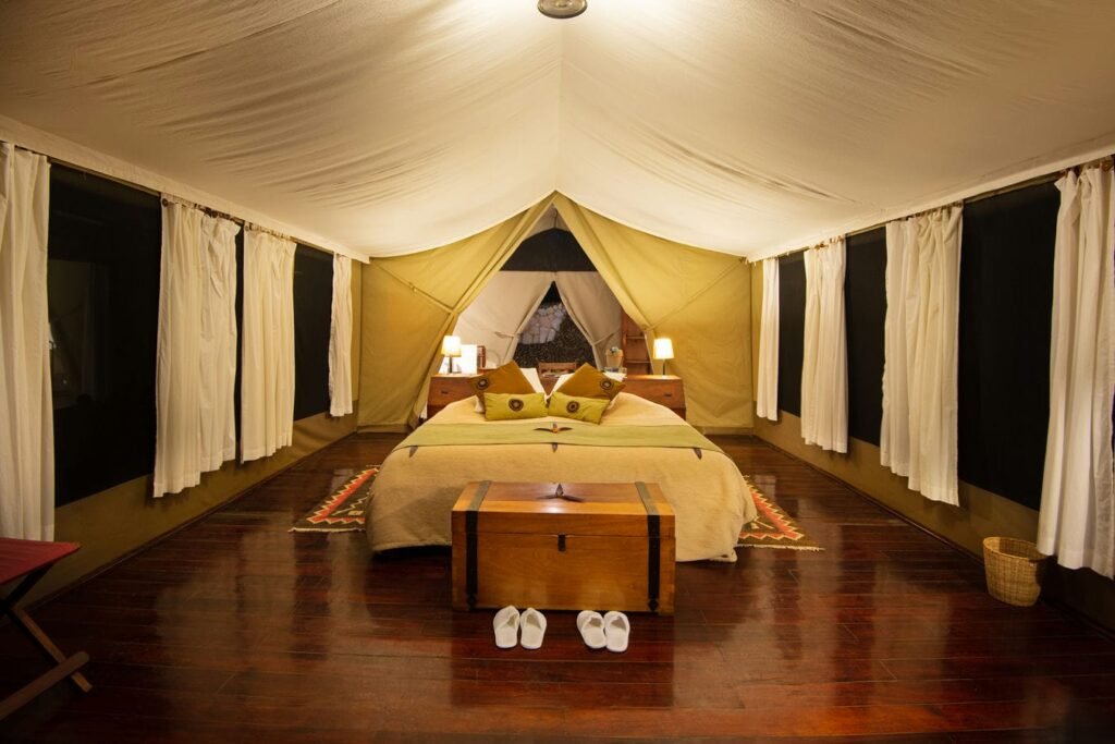 Maasai Mara lodges and camps 40 Karen Blixen Camp double tent with canvas walls, wooden floor and private bathroom beyond the bed