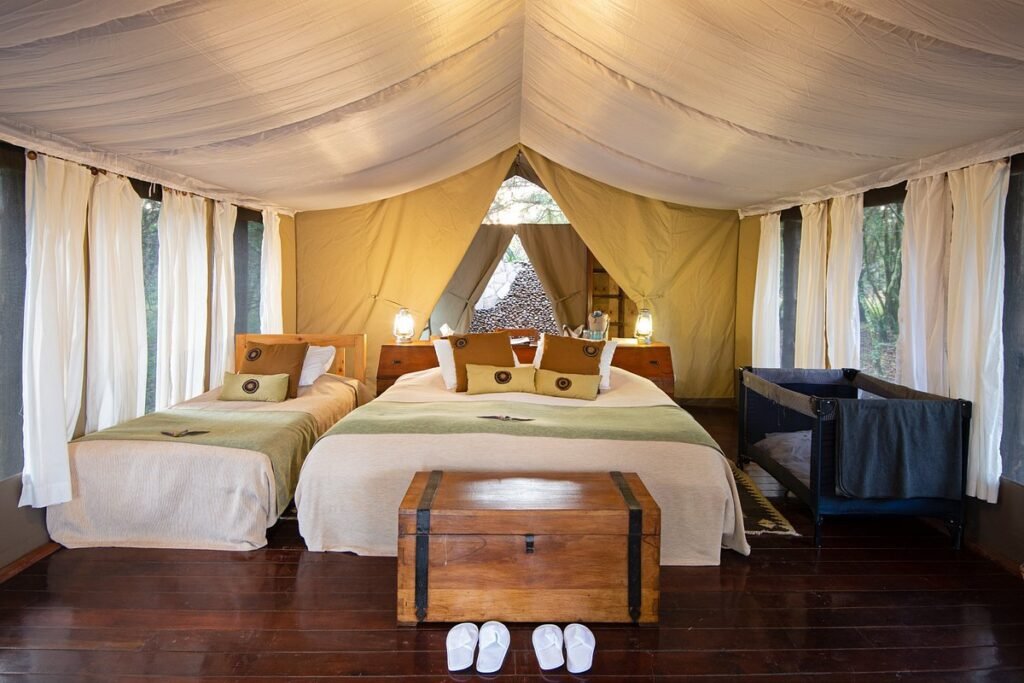 Karen Blixen Camp canvas tent interior with a double bed and extra single bed