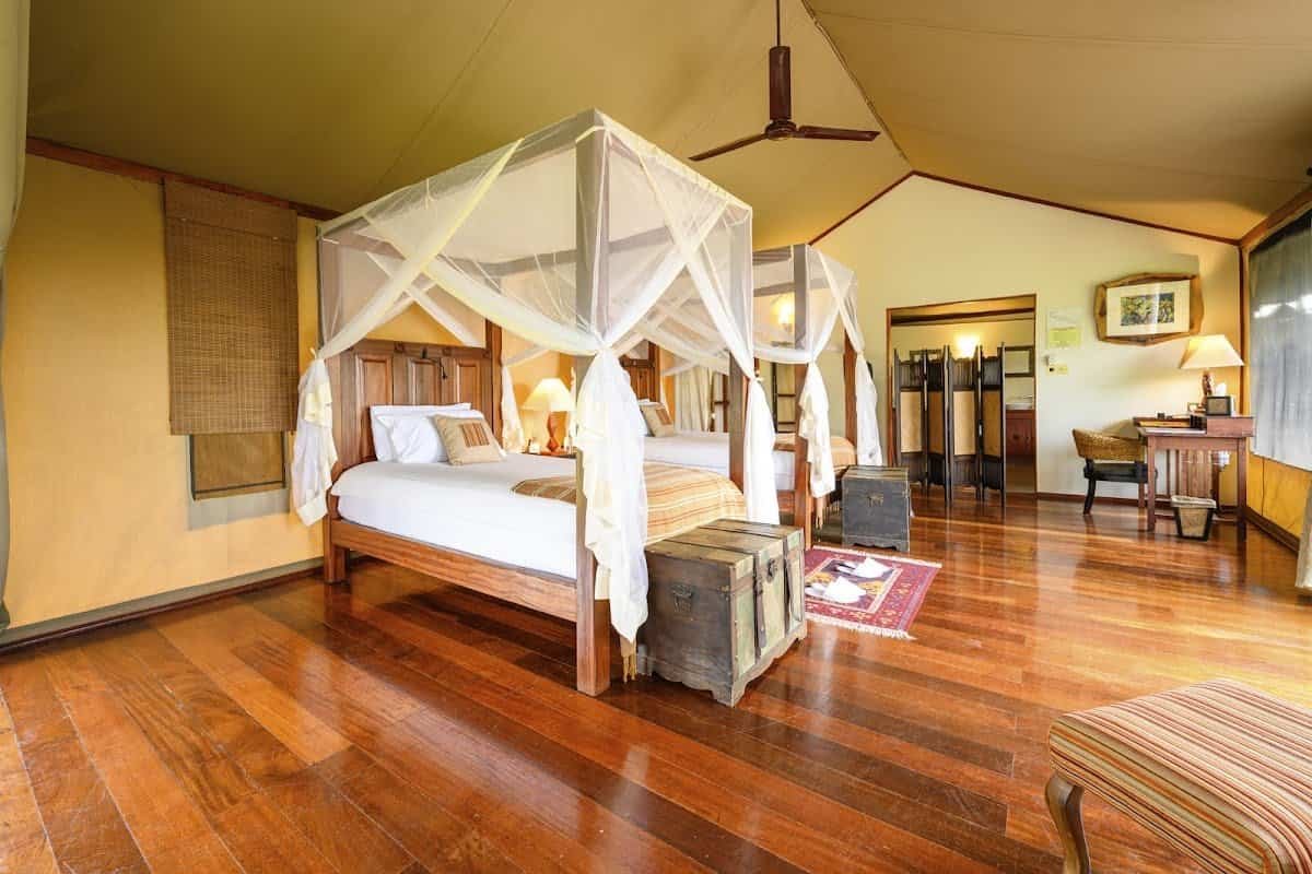 Olare Mara Kempinski canvas tent interior with twin netted beds and wooden flooring