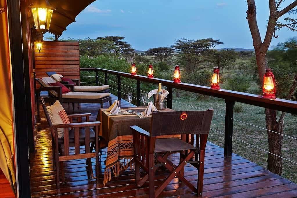 Lanterns and a dining table on a tent veranda at Olare Mara Kempinski