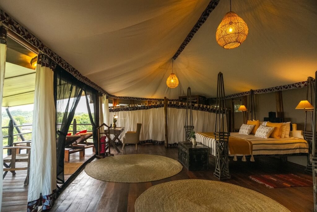 Twin beds and canvas ceiling inside a Kilima Camp guest tent