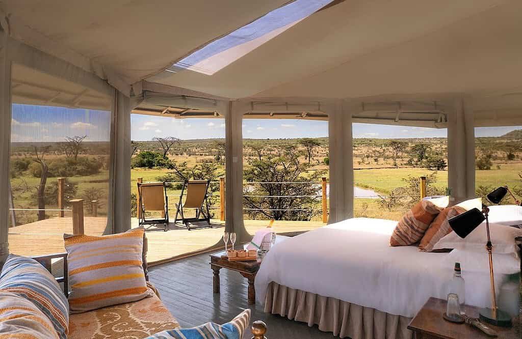 Saruni Leopard Hill tent interior with canopy opening and deck beyond the bed