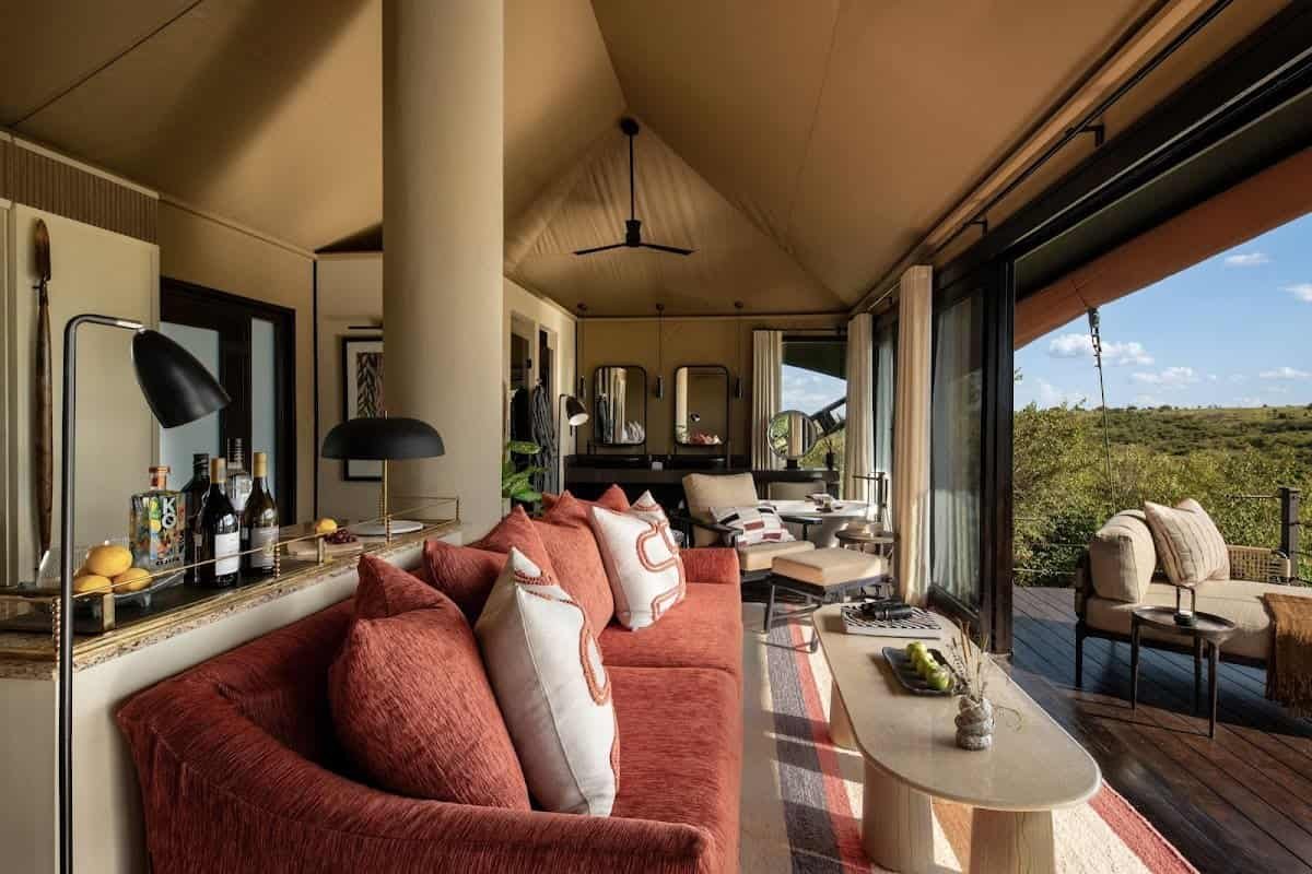 Luxury camps in the Maasai Mara: a furnished lounge opening towards a private veranda