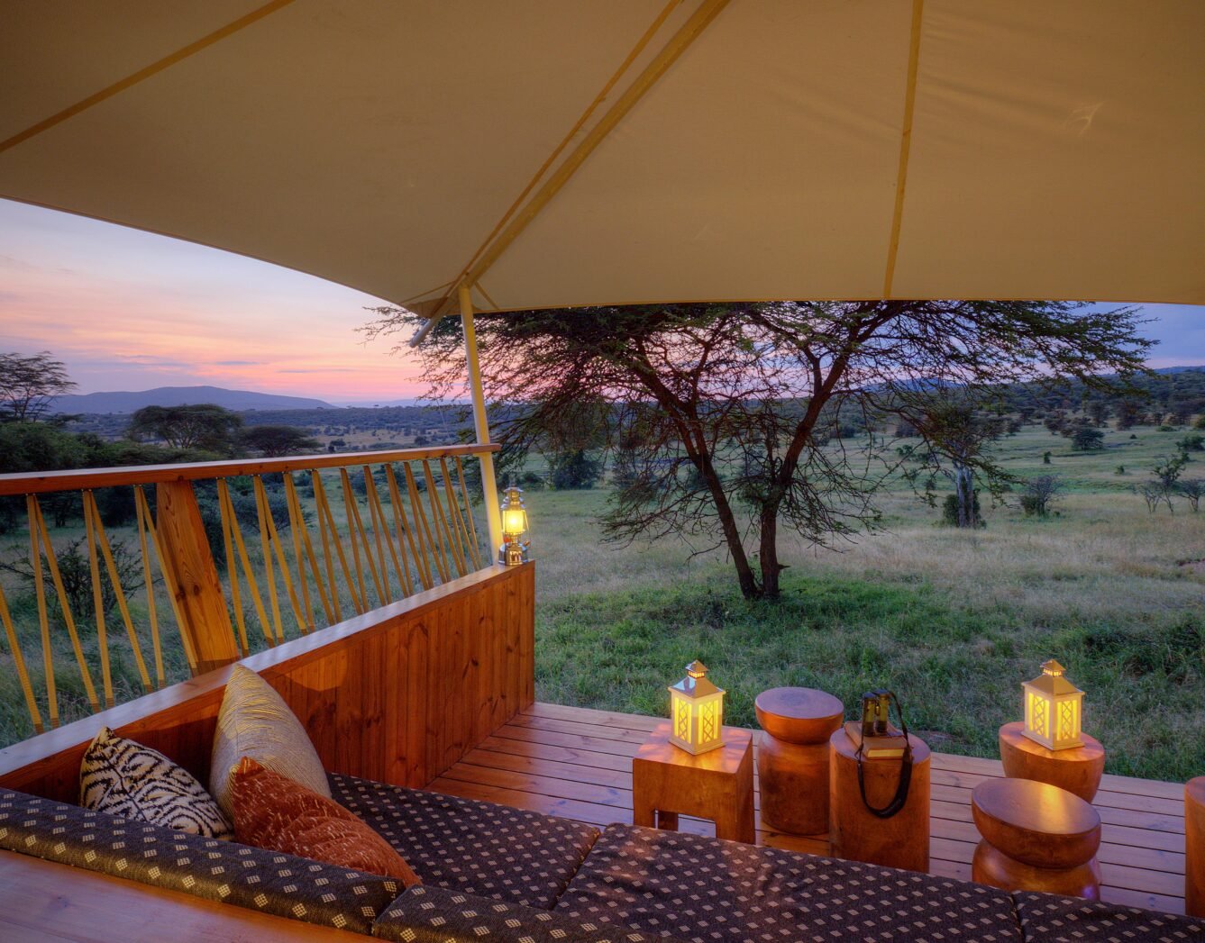 Mara Bushtops private tent deck with seating and lanterns overlooking conservancy woodland