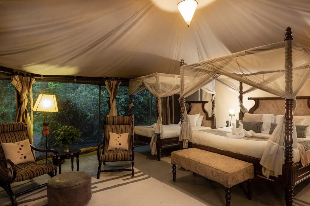Maasai Mara lodges and camps 32 Mara Ngenche Safari Camp four-poster tent bedroom with canopy and sitting area
