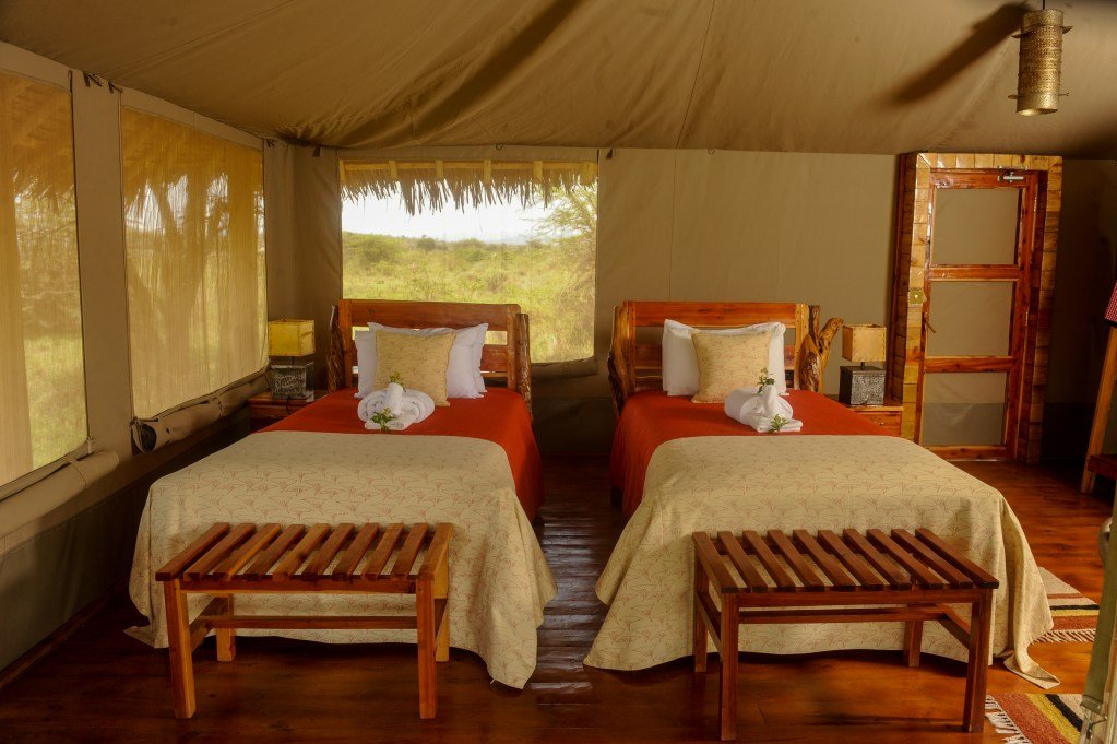 Mara Siana twin bedroom with timber beds beneath canvas and thatch