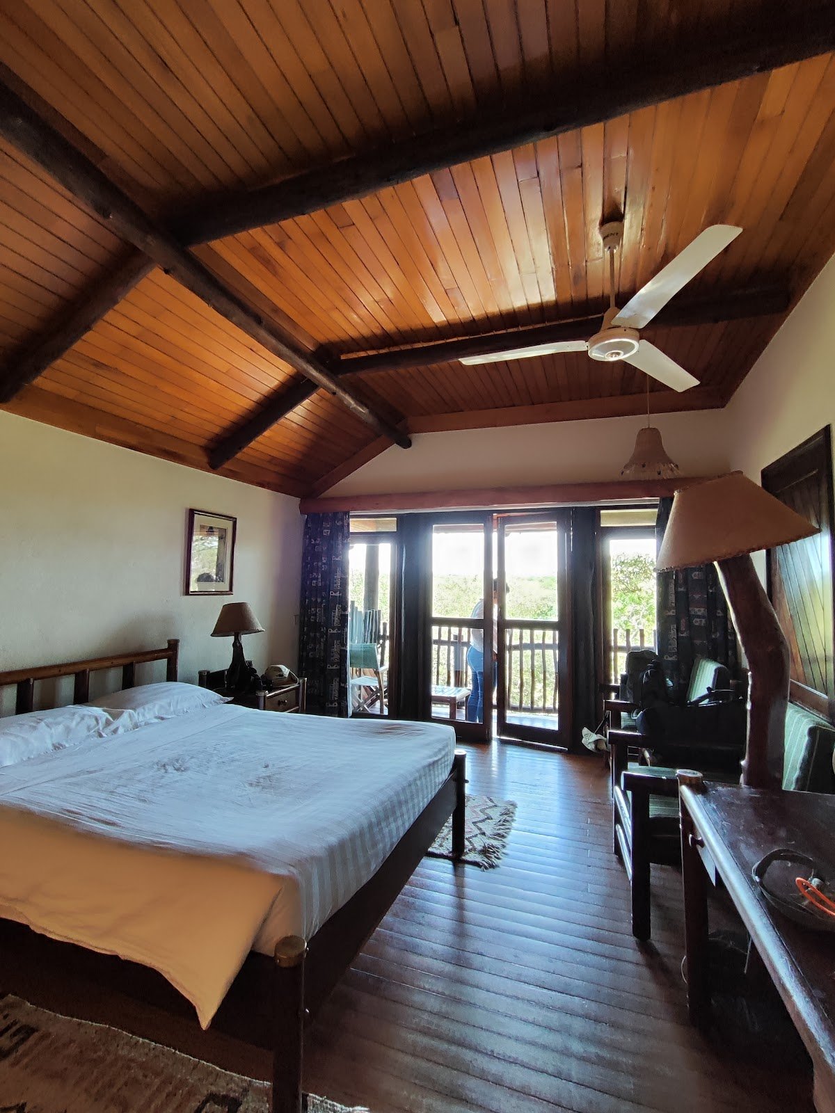 Mara Simba Lodge bedroom with timber ceiling, fan and veranda doors
