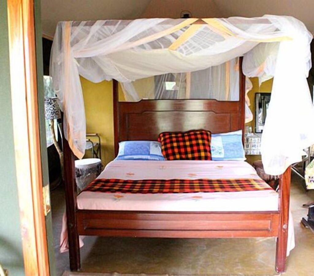 Mara Springs Safari Camp en-suite double room with mosquito net and timber bed