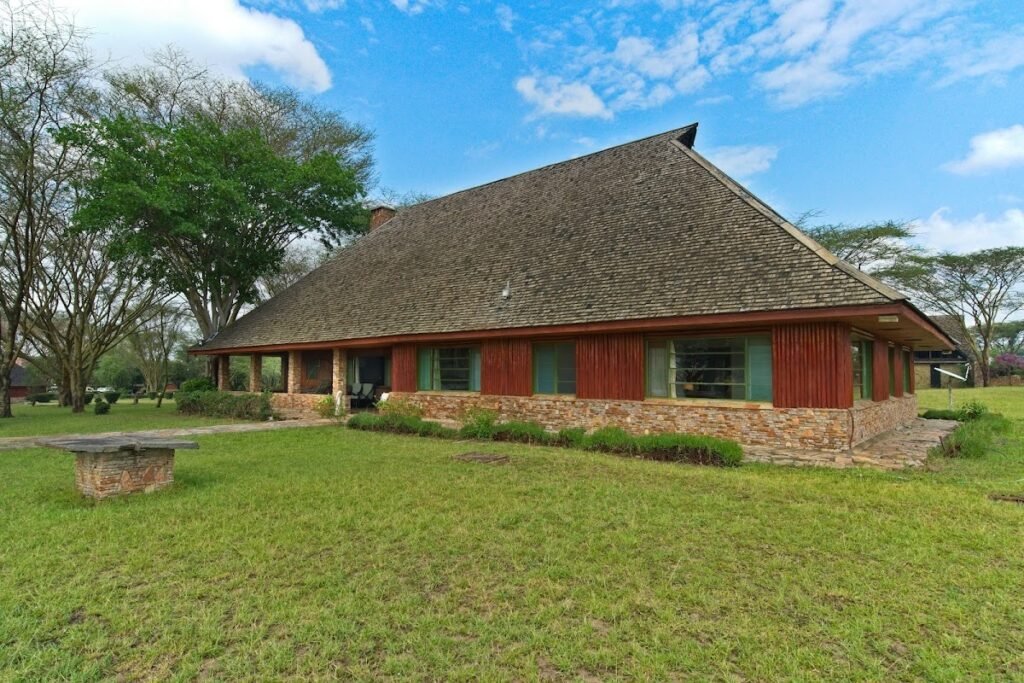 Maasai Mara lodges and camps 79 Red timber and stone lodge building on the lawns at Muthu Keekorok Lodge