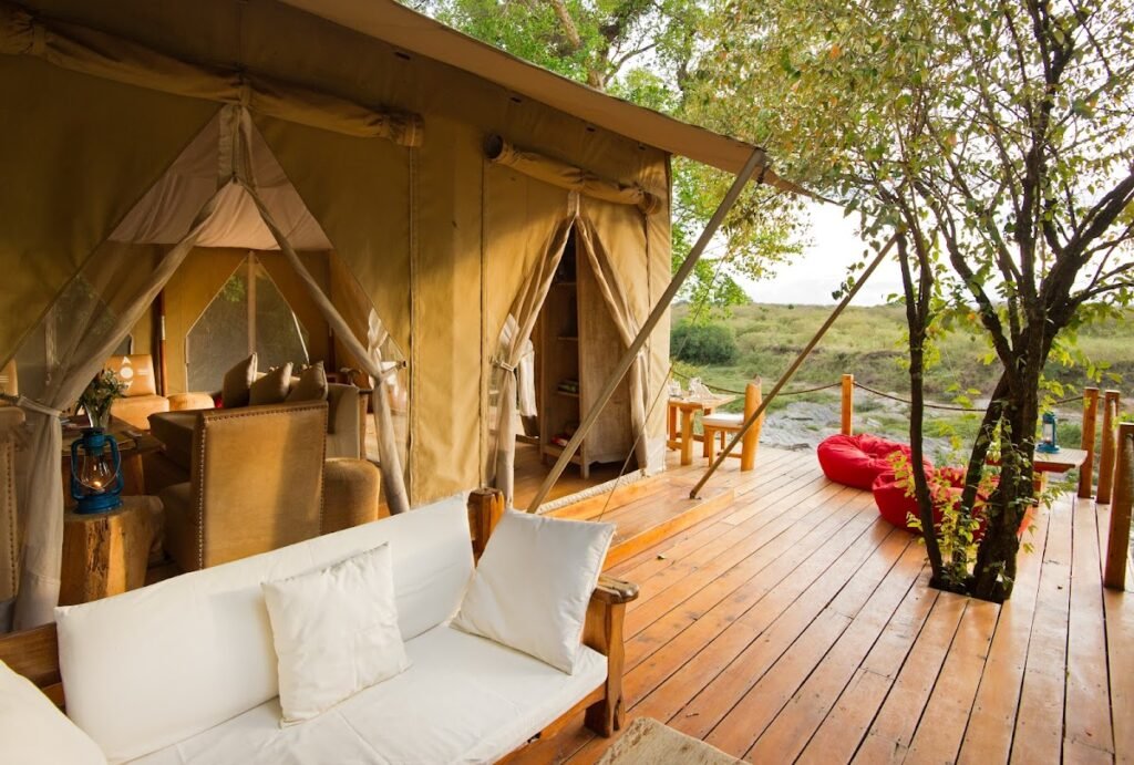Maasai Mara lodges and camps 40 Naibor Camp canvas accommodation opening onto a shaded wooden veranda