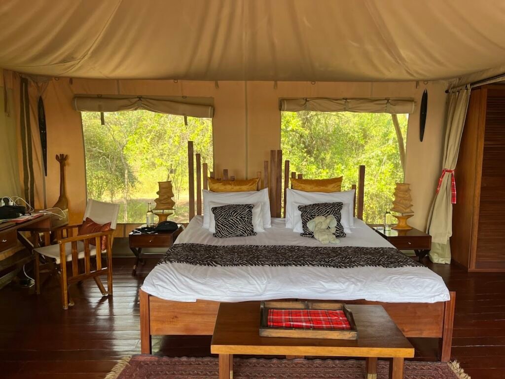 Maasai Mara lodges and camps 86 Neptune Mara Rianta luxury tent with wooden king bed and views through canvas windows