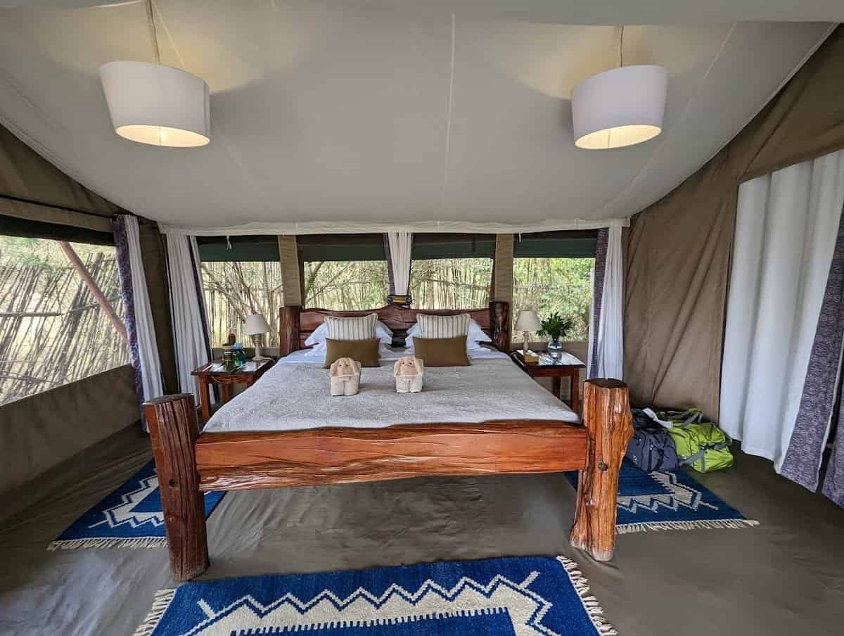 Offbeat Mara Camp double bedroom with timber bed frame and blue patterned rug