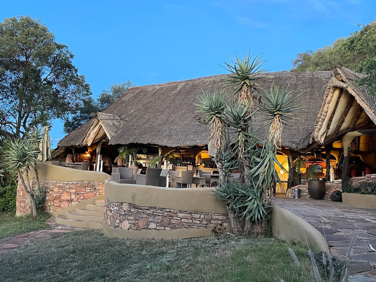 Olarro Lodge thatched shared area with curved terrace walls in the hillside setting