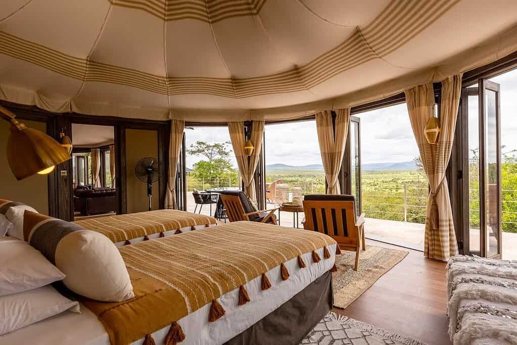 Twin beds beneath a patterned canvas ceiling in a Nina Tent at Hemingways Ol Seki Mara