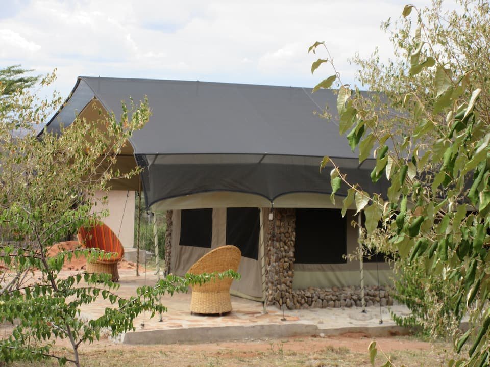 Maasai Mara lodges and camps 47 Oseki Mara Camp canvas safari tent with shaded veranda and wicker chairs