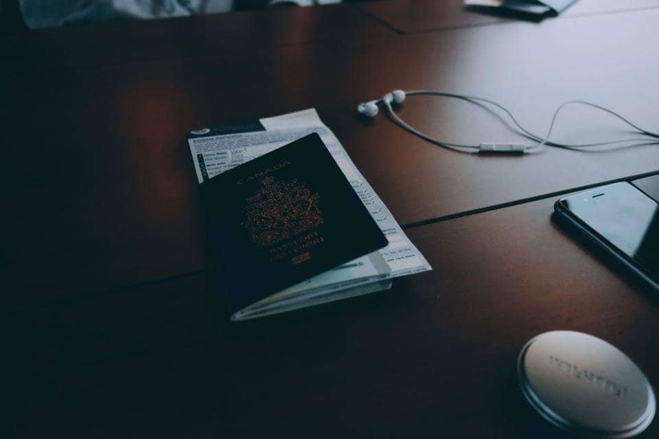 A passport lying on a customs declaration form on a wooden table