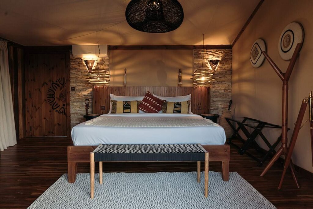 Pearl Mara family-suite bedroom with a double bed, patterned bench and warm wall lights