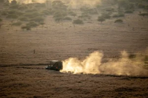 Mara Journal 7 Maasai Mara packing list guide: safari vehicle raising dust on a dry grassland track