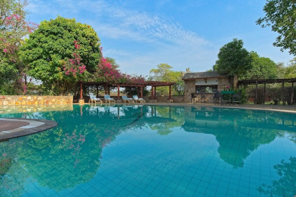 Curved swimming pool and stone pool-bar building at Keekorok Lodge