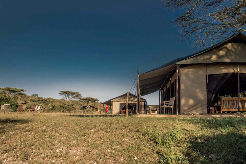 Maasai Mara lodges and camps 100 Porini Cheetah Camp guest tent with a shaded canvas veranda and safari chairs