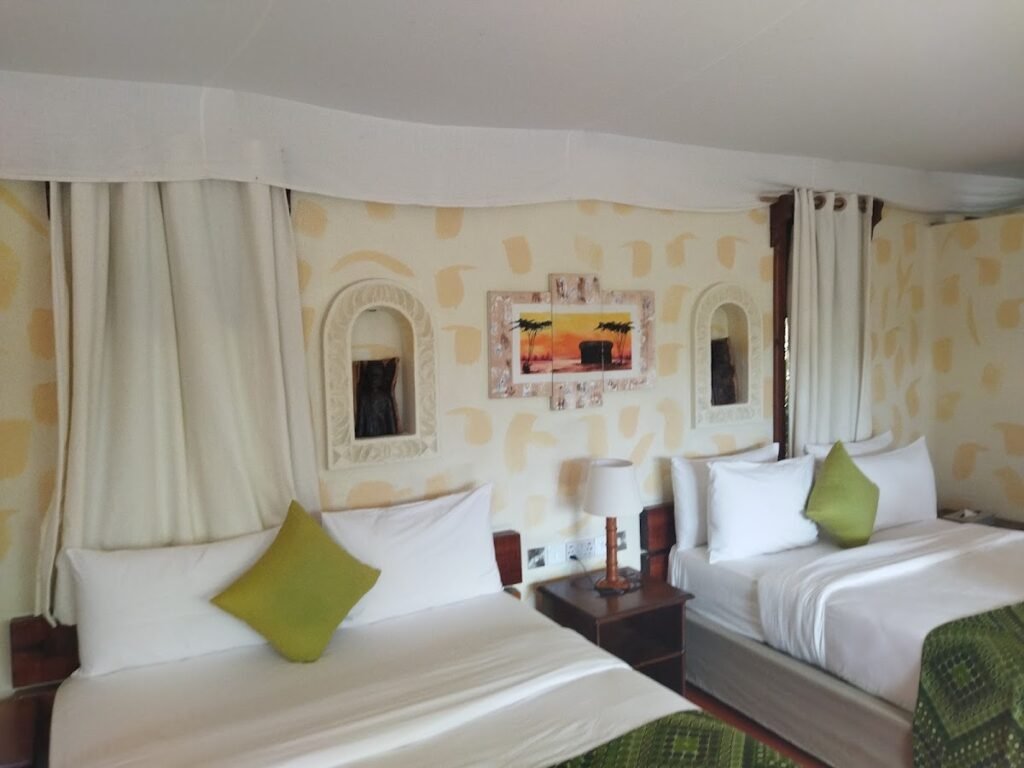 Maasai Mara lodges and camps 103 PrideInn Mara Camp twin bedroom with green cushions and canopy above the beds