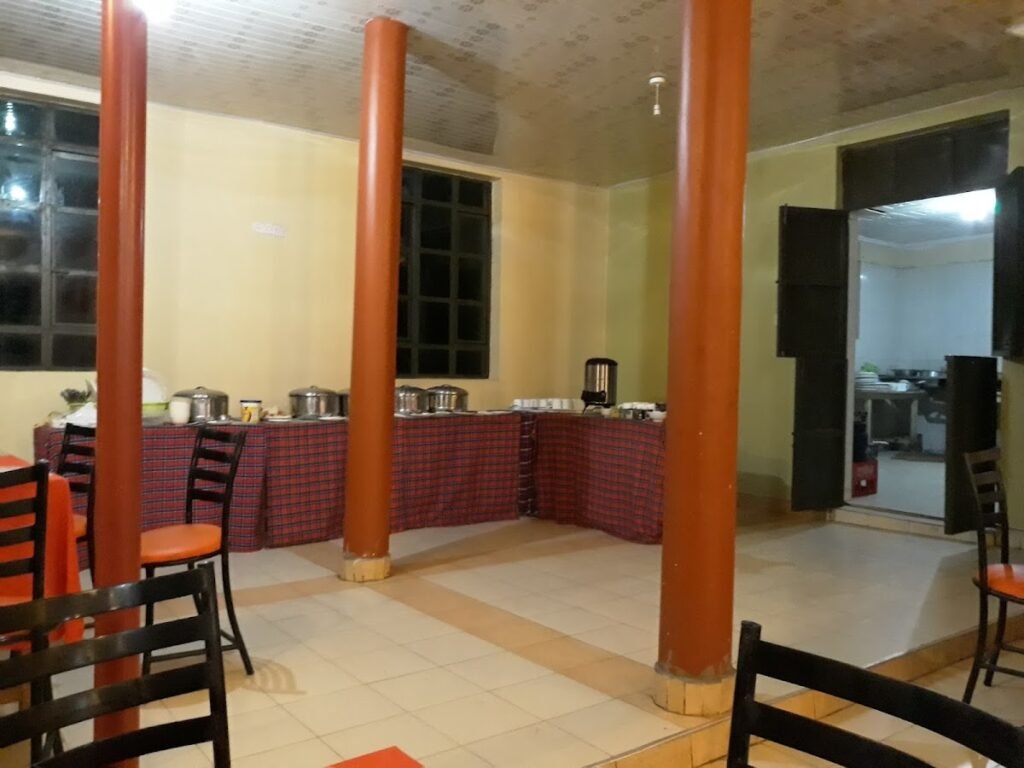 Rhino Tourist Camp buffet dining room with orange pillars and checked serving-table cloths