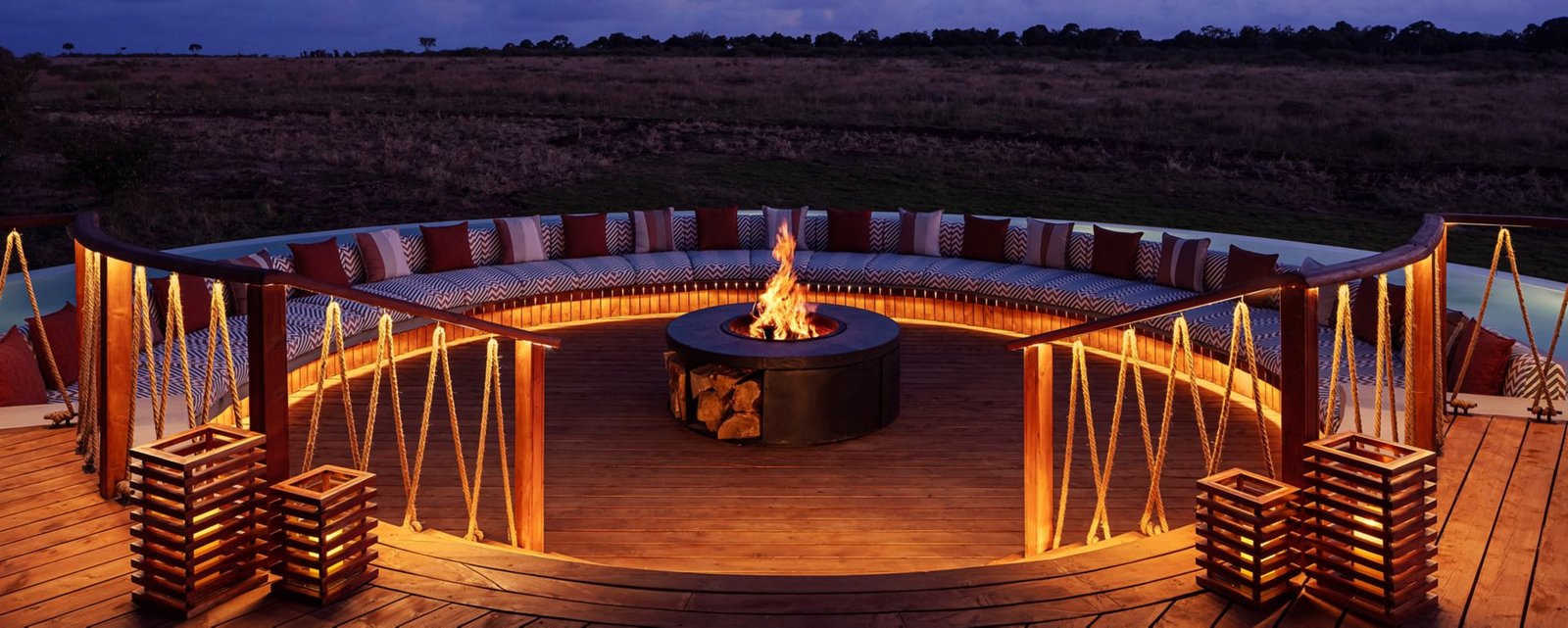 The Ritz-Carlton Maasai Mara Safari Camp Canopy firepit lounge with curved seating and timber deck