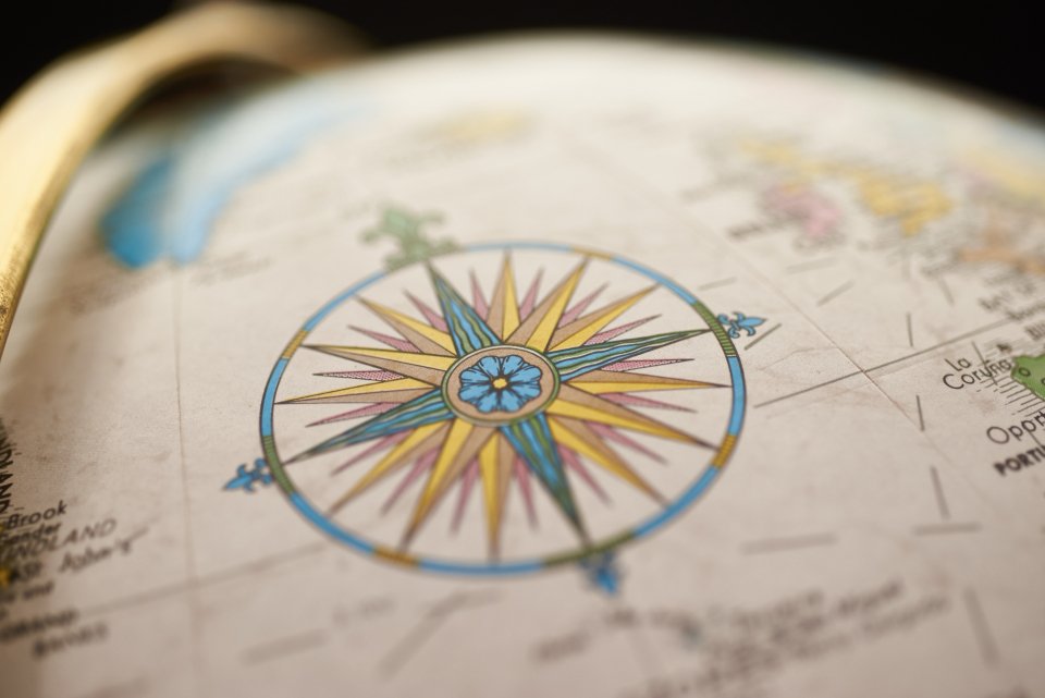 Compass rose on a globe for booking your Maasai Mara safari and planning an international journey