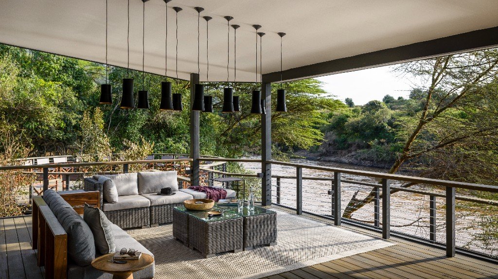 Sanctuary Olonana river-facing glass terrace with hanging lights and lounge seating