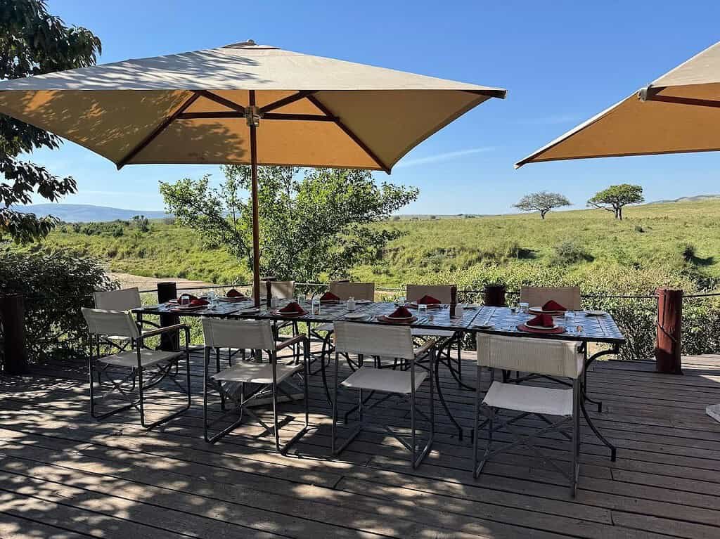 Outdoor dining deck with shaded tables at Elewana Sand River Maasai Mara
