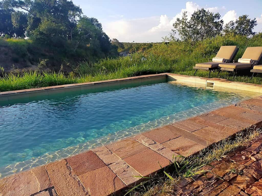Swimming pool beside the riverine vegetation at Elewana Sand River Maasai Mara