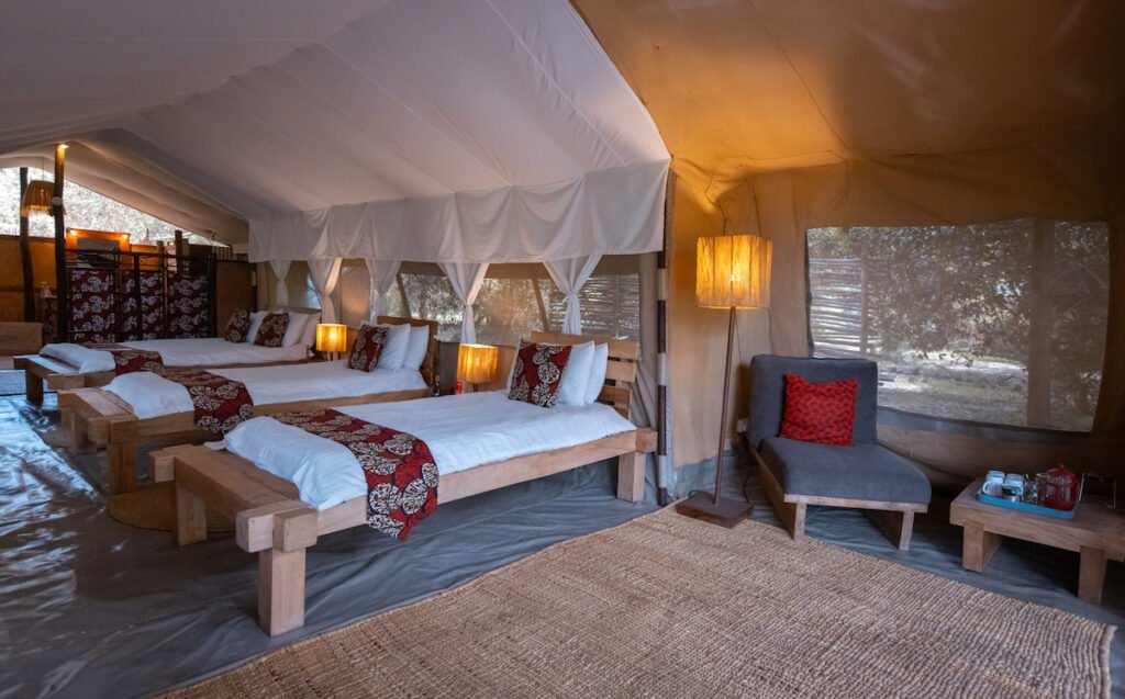 Speke's Camp furnished safari tent with multiple single beds and mosquito nets