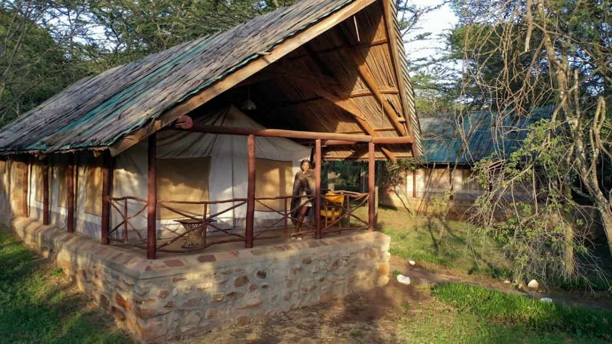 A thatched-roof tent with a shaded veranda at Sentrim Mara