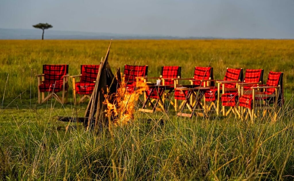 Royal Mara red safari chairs around an outdoor fire on the conservancy plain