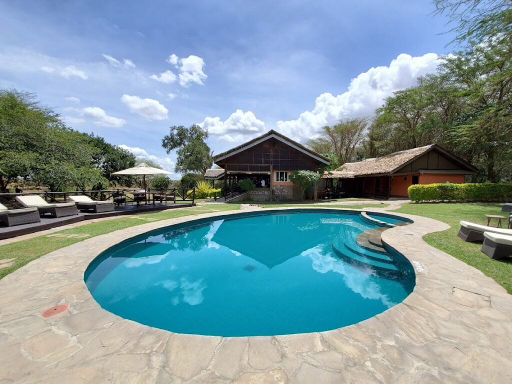 Maasai Mara lodges and camps 125 Tipilikwani Mara Camp shared swimming pool beside the thatched main building